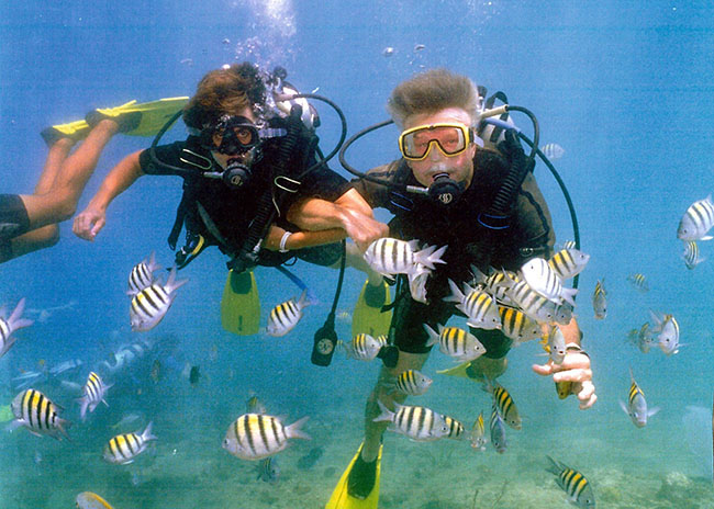 Ronald and his brother in the middle of fish in their discover scuba diving tour.
